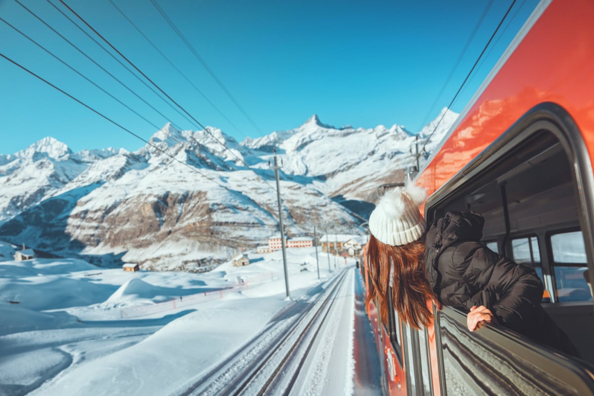 woman looking at a snowy landscape from a train