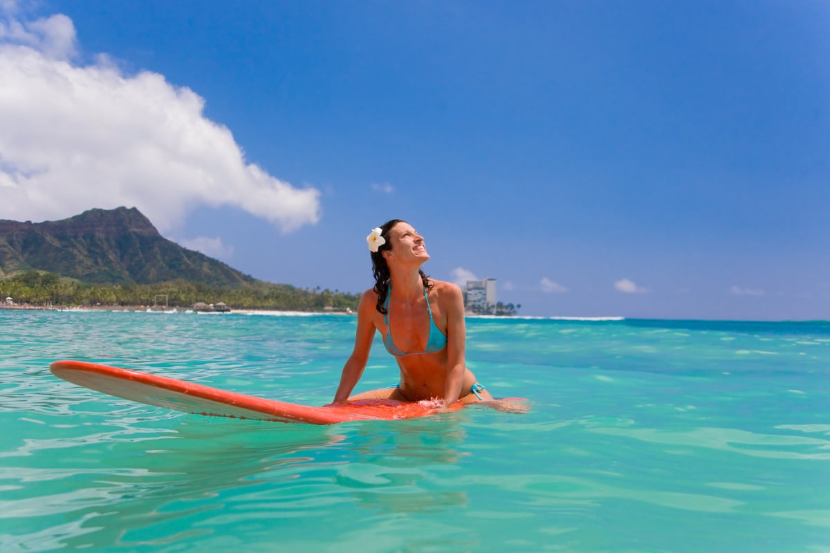 woman on a red surfboard in waikiki, diamond head, oahu