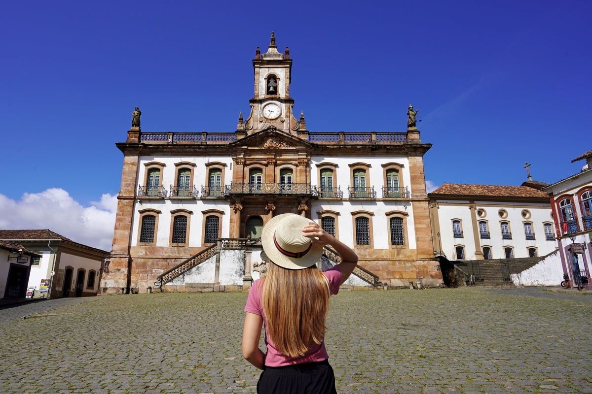 A Young Female Tourist Admiring A Colonial Building In Ouro Preto, Minas Gerais, Brazil